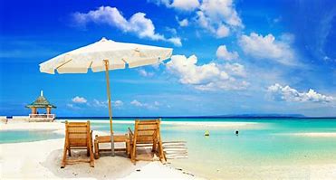 Chairs on the beach facing clear, blue water.