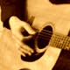 Man with glasses and hat poses with guitar